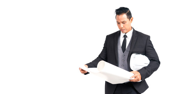 肖像亚洲英俊的男子在西装建筑师，工程师和商业持有蓝图纸和在白色背景的头盔建设。图片下载