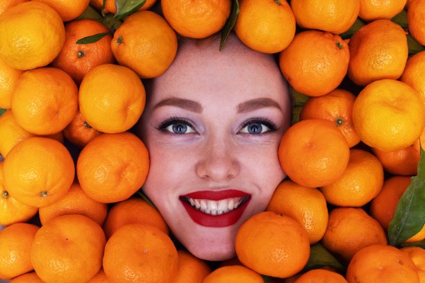 一个漂亮姑娘的脸，带着微笑，带着橘子图片下载