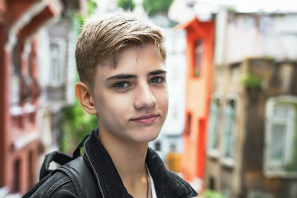 高中生的肖像，拿着书包在上学或放学回家的路上，微笑着看着镜头图片下载