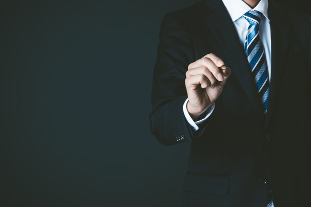 黑色背景，穿着西装的商人拿着笔图片下载