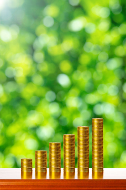 黄金货币和绿色模糊的背景图片下载