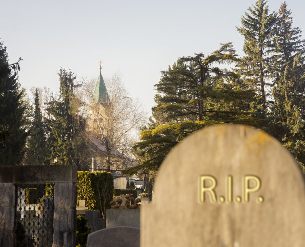 有模糊撕裂标志的墓碑和远处的教堂图片下载