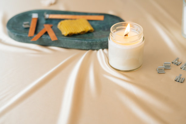 近景拍摄的成分生产芳香生态手工蜡烛在光的背景。图片下载