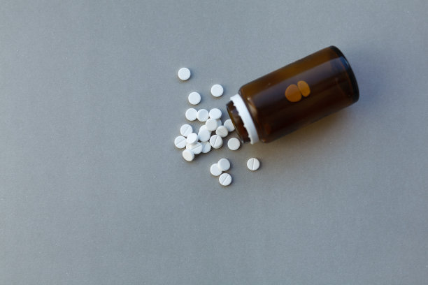 白色药丸(药)从棕色的瓶子里溢出来图片下载
