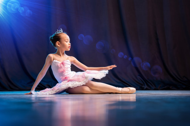 小芭蕾舞女演员在舞台上跳舞，白色芭蕾舞鞋经典变化。图片下载