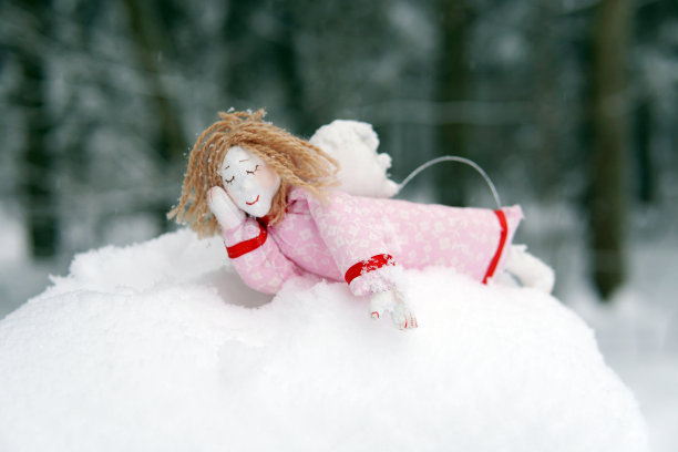 森林里沉睡的天使。雪地里的玩具。图片下载