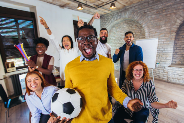 快乐的休闲商务人士或球迷在电视上观看足球比赛，庆祝胜利。友谊、体育和娱乐观念。图片下载