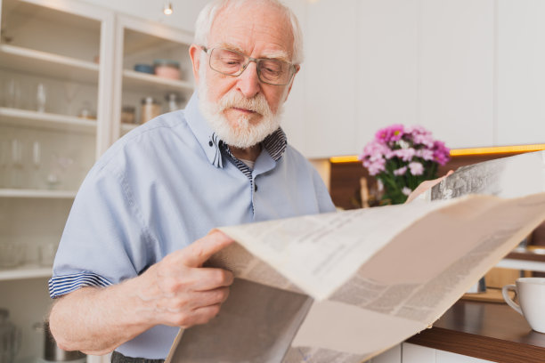 老人在家里吃早餐看报纸图片下载