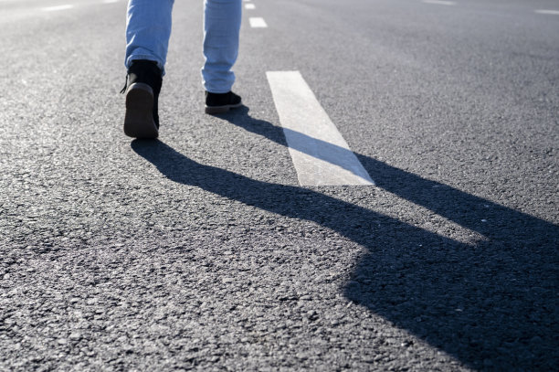 人走在路上，阳光下有剪影图片下载