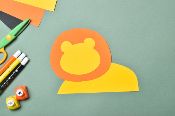 DIY的狮子。我们用彩纸做了一只狮子。一步一步的指示。第二步:把头部和身体粘在一起。平躺，俯视图图片下载