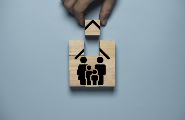 ็手握木制立方体完成组装家庭保险图标，保险对于管理未来可能发生的风险很重要，无论是我们自己还是我们的家庭概念。图片下载