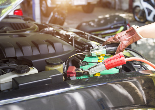通过跨接电缆给汽车电池充电。图片下载