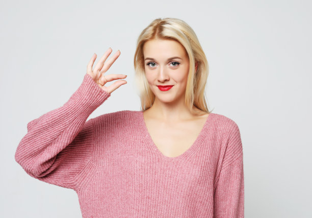 一个快乐的年轻女孩的肖像显示ok的手势和眨眼图片下载