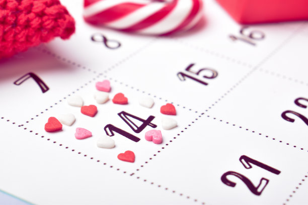 有情人节标志的日历。2月日历上的彩色棒棒糖和礼品盒。副本的空间。平躺，俯视图图片下载