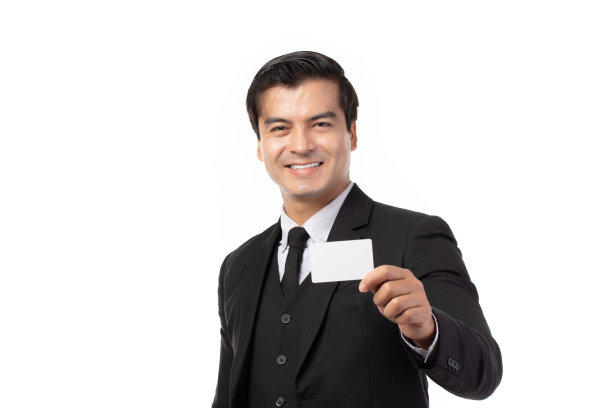 英俊的商人，穿着黑色西装拿着白色背景的信用卡。商业，技术，电子商务和在线支付的概念。图片下载