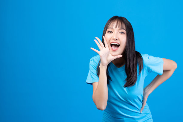 美丽的年轻亚洲女孩模特的肖像长发在休闲夏装微笑，快乐和享受在工作室孤立的黄色背景。图片下载