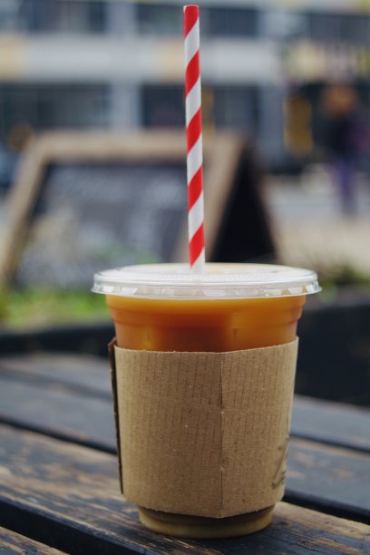 用一次性杯子盛冰咖啡，吸管是红白两色的图片下载