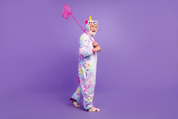 迷人的有趣的男人养老金独角兽睡衣的照片散步捕捉蝴蝶微笑孤立的紫罗兰色背景图片下载