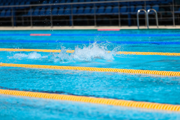 游泳池里水溅起水花。暑假假期。图片下载