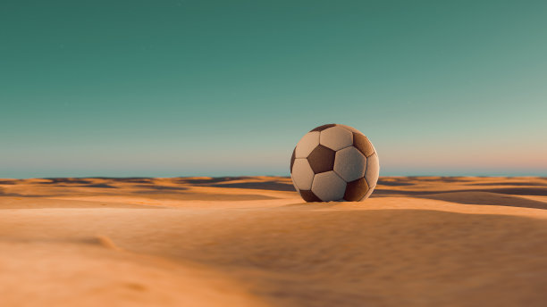 日落时分，在沙漠的沙滩上踢足球图片下载