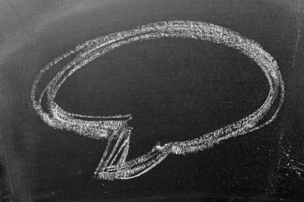 用白色粉笔在黑板或黑板背景上画出圆形的气泡语音形状图片下载