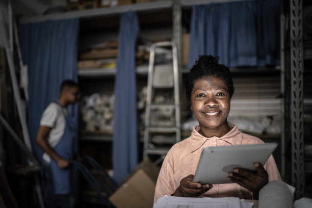 一个成熟女人在储藏室里用数码平板电脑工作的肖像图片下载