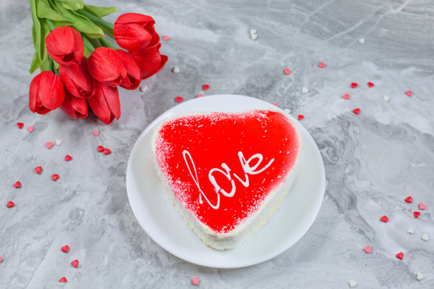 心形蛋糕和节日大理石背景上的郁金香花束。情人节的概念。图片下载