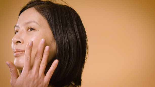 美丽的亚洲女性使用化妆产品在的背景图片下载