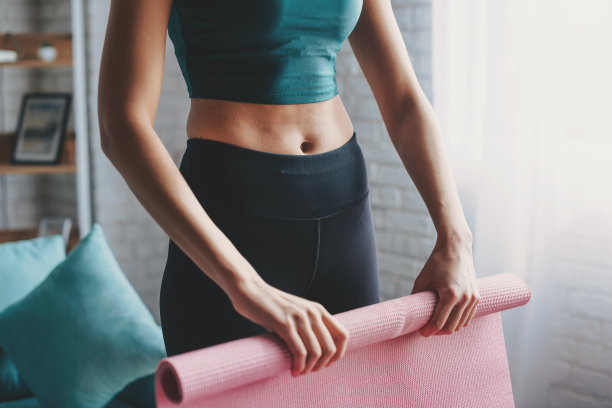 瑜伽训练结束后，妇女的双手折叠地毯。健康的生活方式。生活方式的概念。图片下载