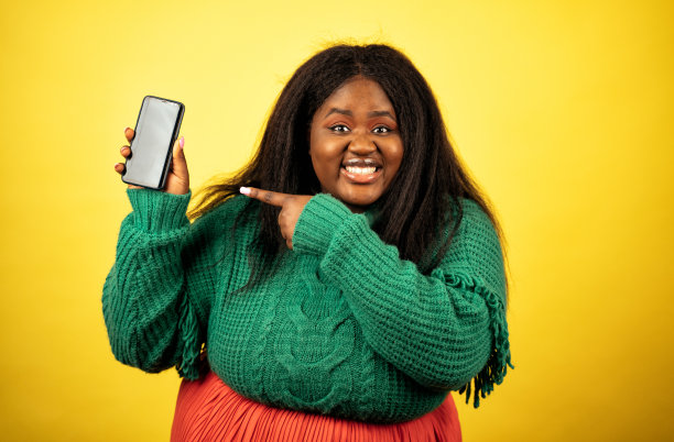 一个穿着休闲服装的漂亮女人在黄色背景上摆姿势的照片图片下载