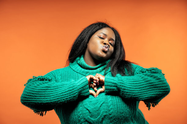 一个美丽的女人在一个彩色的背景上穿着休闲服装摆姿势的图像图片下载