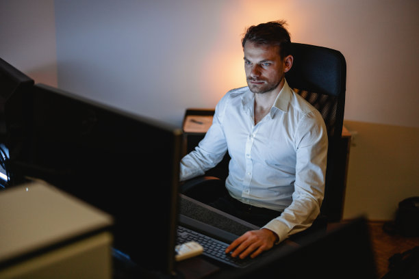 商人深夜在办公室用他的台式电脑图片下载