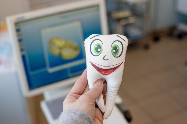 牙科治疗用的牙科设备和牙科器械。牙医用可爱的脸抱着牙齿模型。美丽的微笑和正确的治疗理念。图片下载