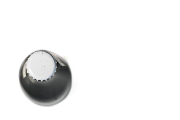 啤酒瓶与金属盖孤立在白色背景的俯视图。图片下载