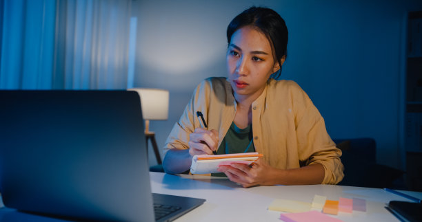 疲惫的年轻亚洲商务女性，穿着休闲服装，在家中客厅用笔记本电脑工作。图片下载