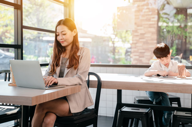 女商人和孩子在咖啡厅工作。手机和数码平板电脑的亚洲家庭生活方式。图片下载