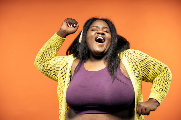 一个美丽的女人在一个彩色的背景上穿着休闲服装摆姿势的图像。图片下载