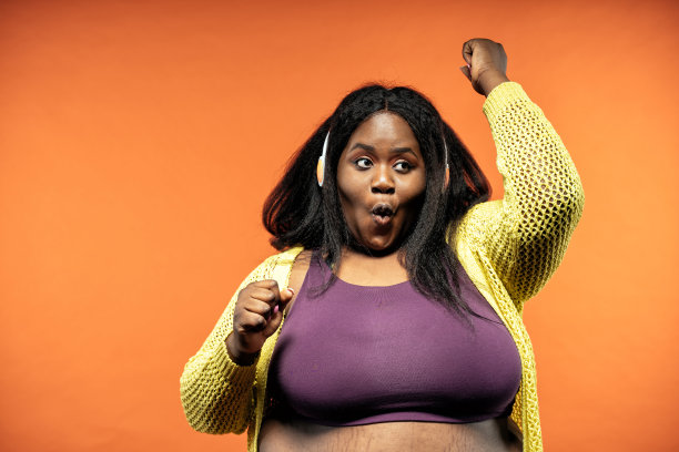 一个美丽的女人在一个彩色的背景上穿着休闲服装摆姿势的图像。图片下载