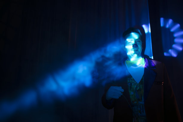 小丑的脸在舞台的蓝光中。图片下载