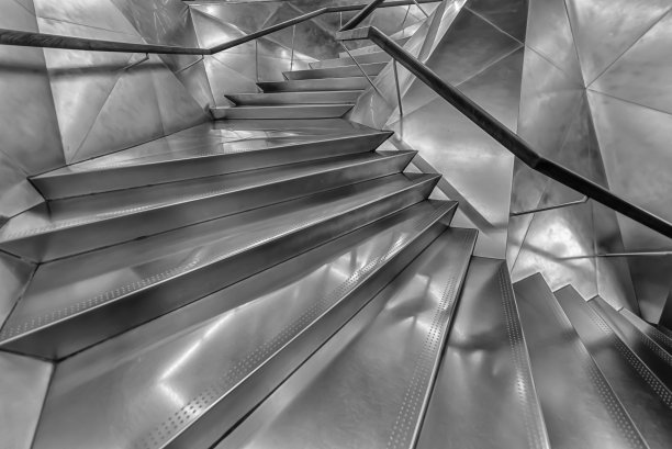银色金属螺旋楼梯，现代楼梯向上带背光。抽象的奢华简约建筑背景图片下载
