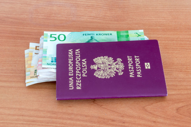 木桌上放着波兰生物识别护照和挪威克朗钞票。图片下载