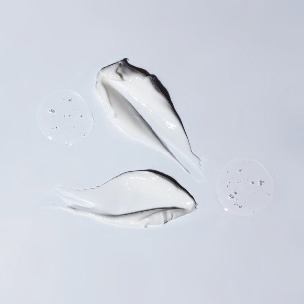 白色化妆品的样本，凝胶和泡沫滴在灰色的背景上。图片下载