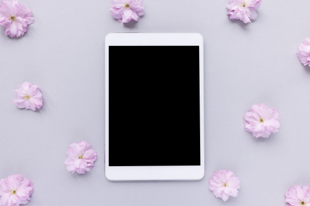 数码平板在春天花粉红色的背景图片下载