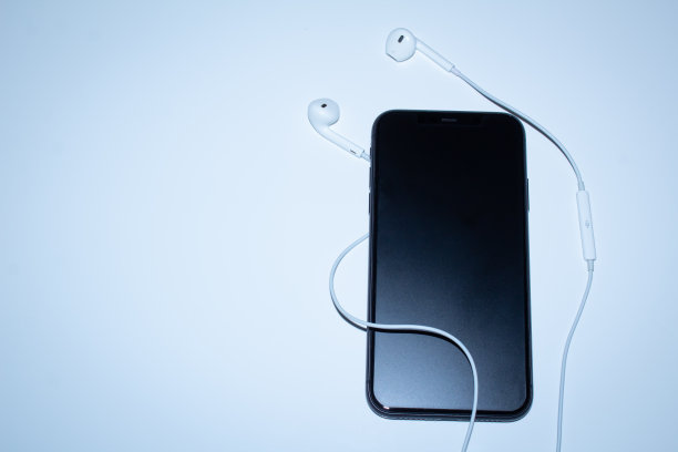 黑色手机，磨砂玻璃和耳机。听音乐的概念。特写镜头。图片下载