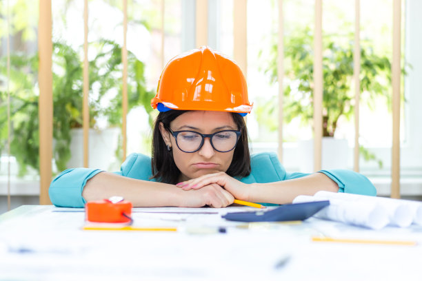 女工程师戴着橙色头盔的照片。图片下载