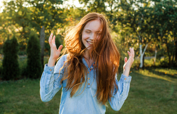 在阳光下的自然背景下，一个美丽的十几岁的模特女孩与红色头发的肖像。图片下载