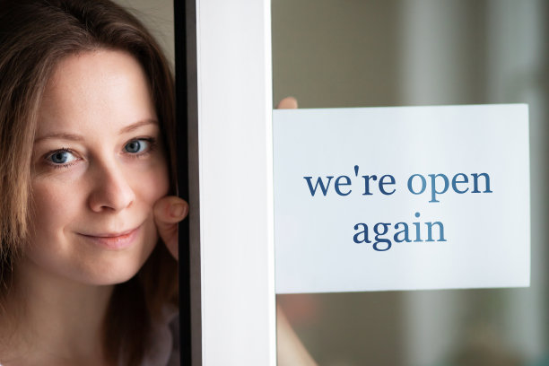 我们又开始营业了，店主在他的商店门口挂着一个标志，在冠状病毒大流行后开始营业，零售和客户服务图片下载