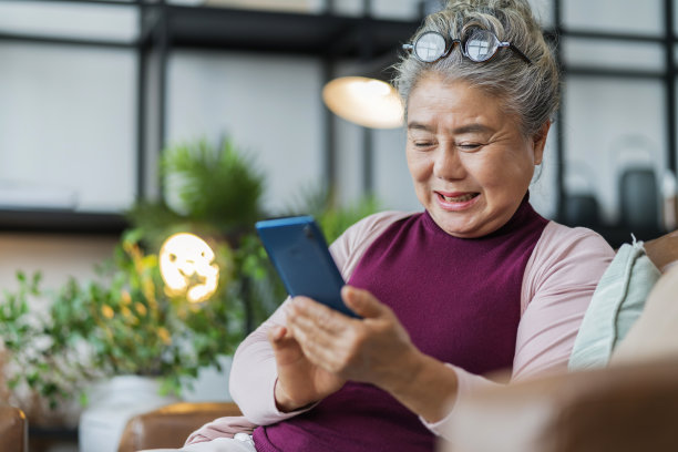 退休的亚洲老年女性休闲布放松生活方式在沙发上的周末早晨，亚洲女性手用智能手机度过假期在互联网智能手机社交网络活动图片下载