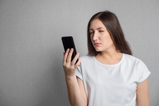 视力不佳的女子盯着手机屏幕看图片下载