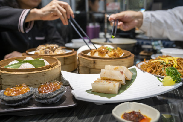 餐馆里用筷子吃广东dum sum的人图片下载